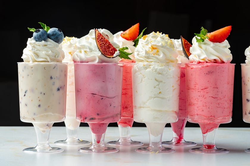 Large collection of mousse desserts in glasses for catering close up