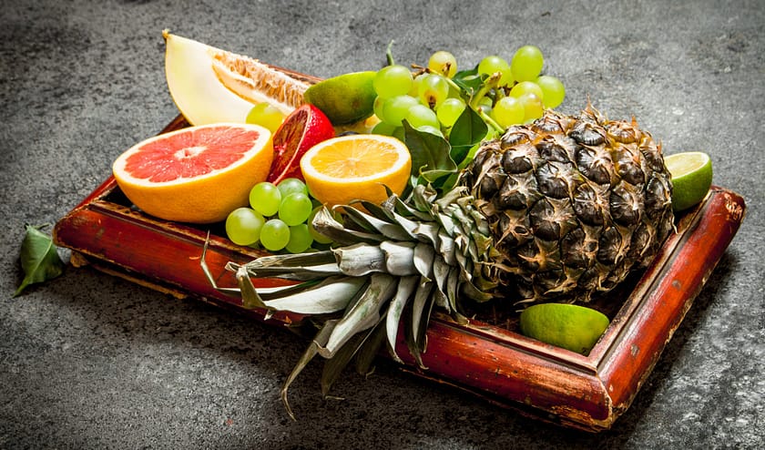Ripe fruits in the old tray. On rustic background .