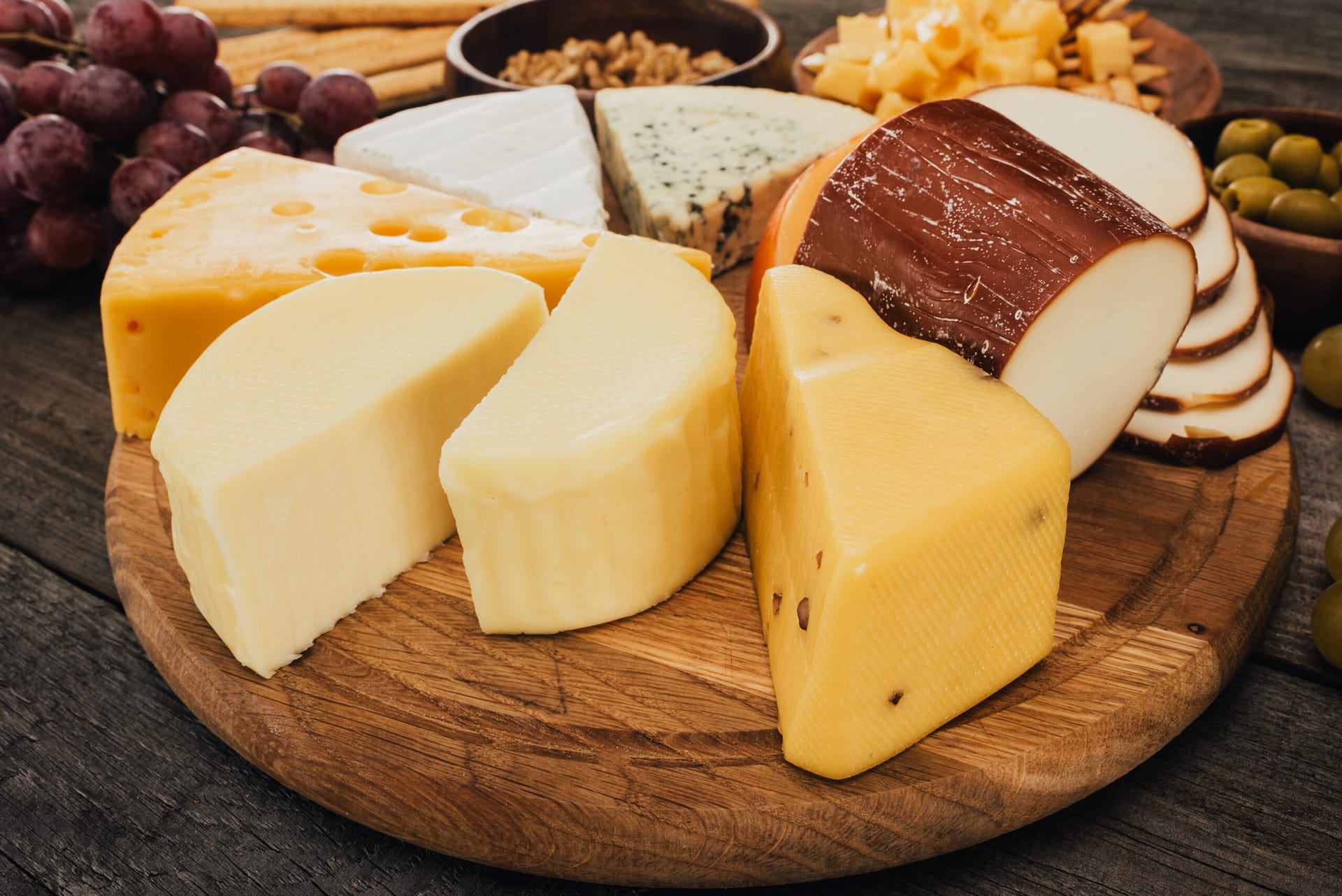 close up view of assortment of cheese on wooden cutting board