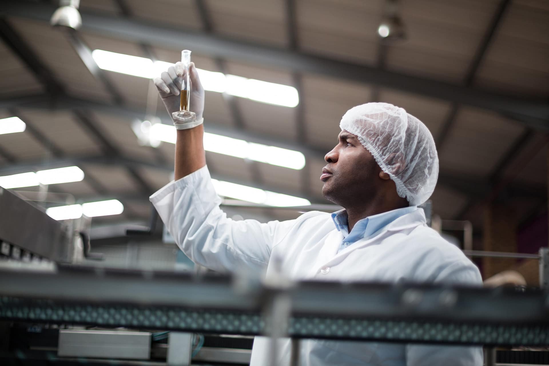 Factory engineers checking a sample of drink in drinks production plant