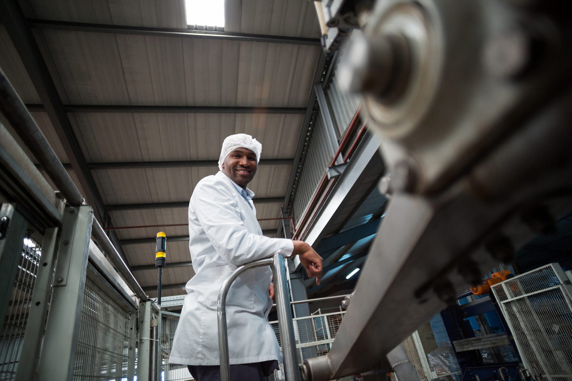 Portrait of smiling factory engineer standing in bottle factory