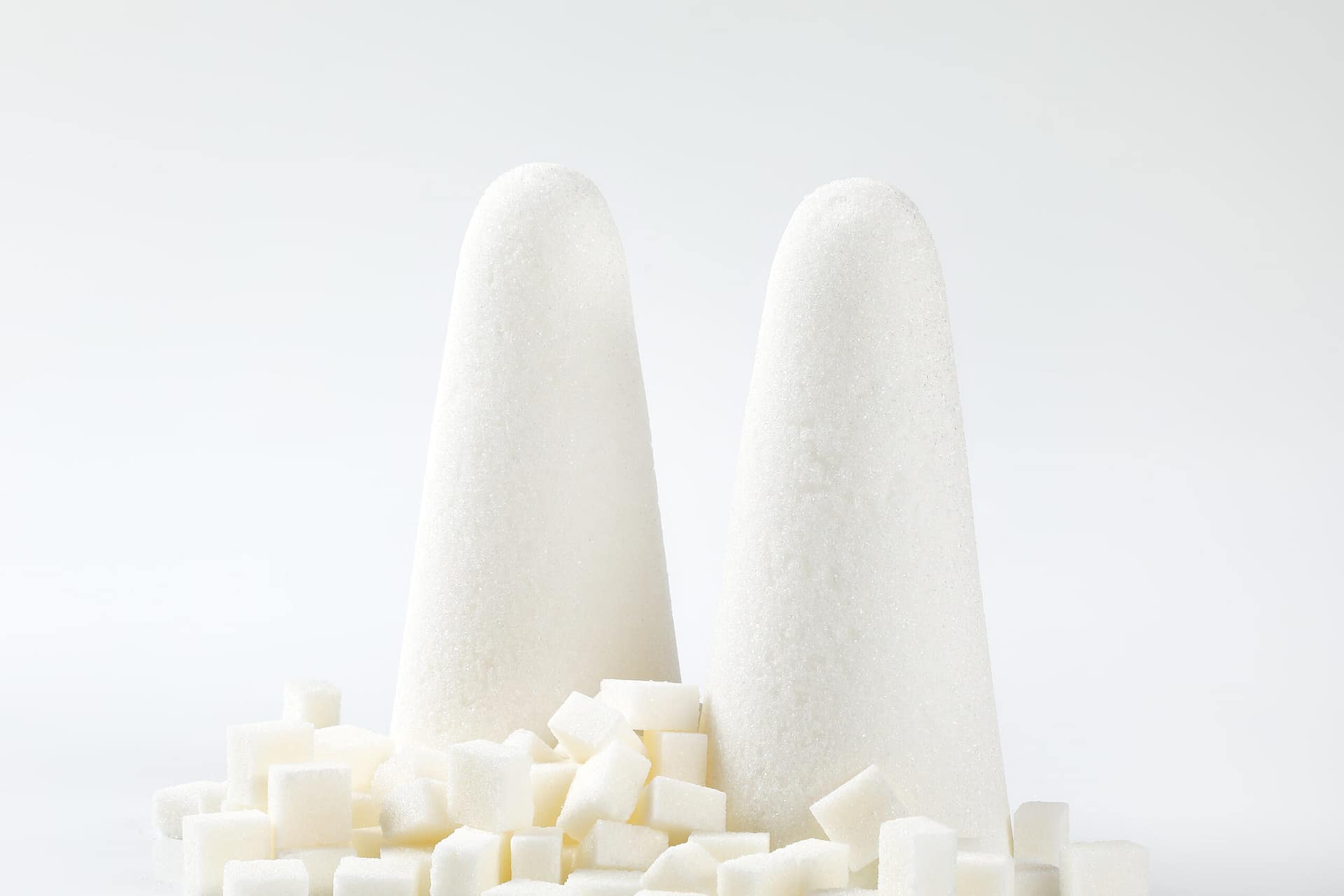 white sugar loaves and cubes on white background